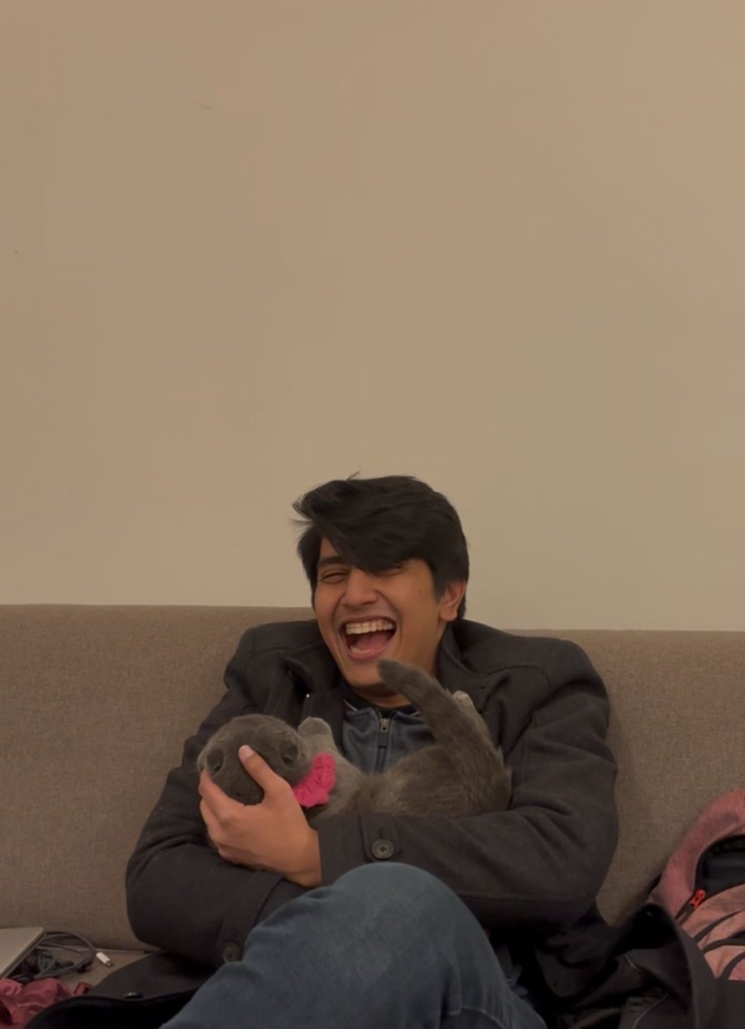 Rupam laughing while holding a cat